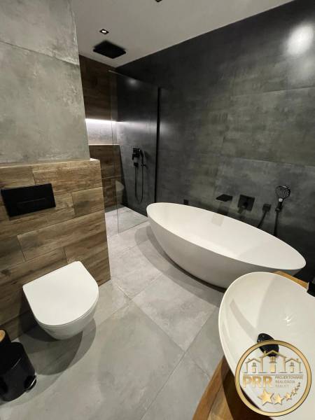 A bathroom in a 3-room apartment with a freestanding bathtub, shower, and sink.
