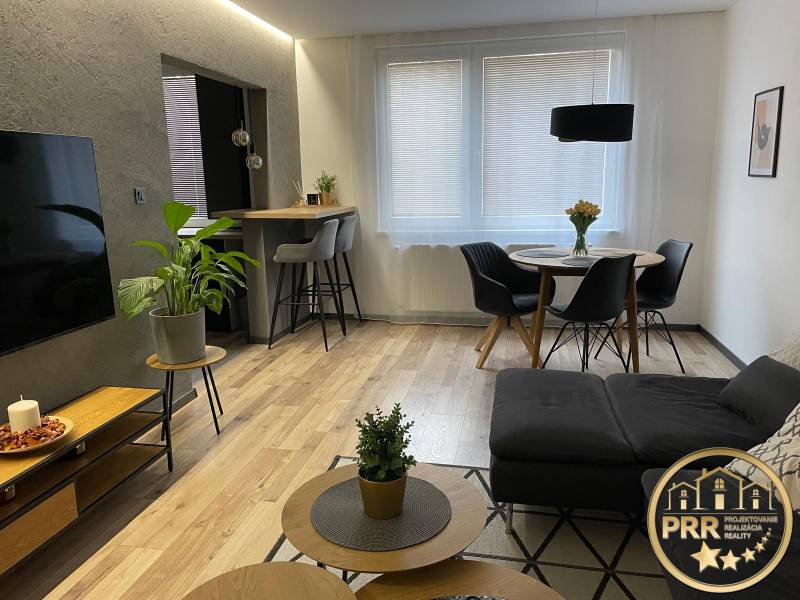 Living room in a 3-room apartment with a sofa, dining table, and television.