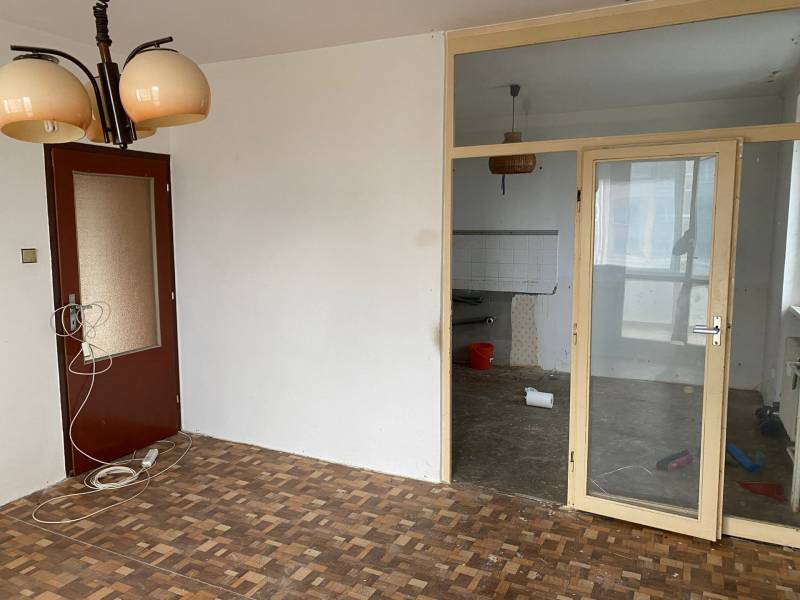 Interior of a 3-room apartment with parquet flooring and glass doors.