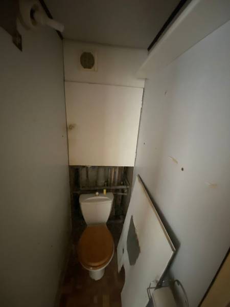 A small bathroom with a toilet and ventilation in a 3-room apartment.