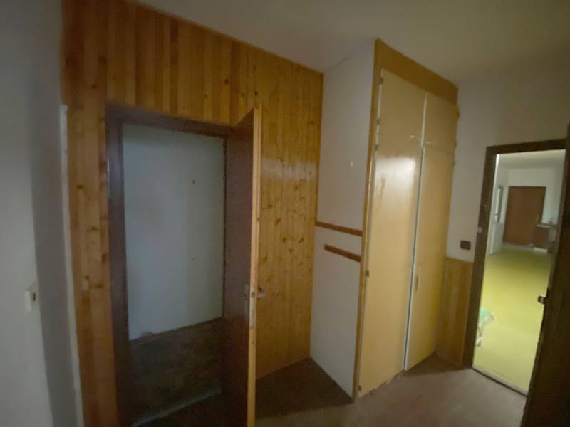 A hallway with wooden paneling and a built-in wardrobe in a 3-room apartment.