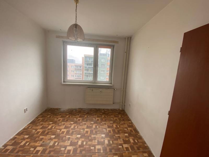 A room with a parquet floor and a radiator in a 3-room apartment.