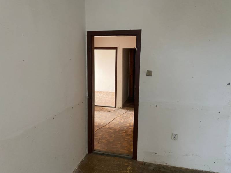 An empty interior with open doors and parquet flooring in a 3-room apartment.