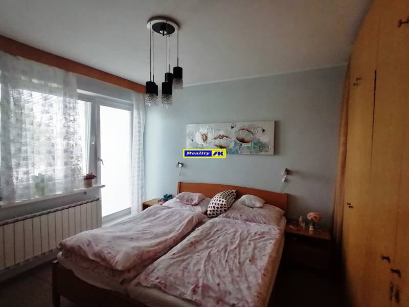 Bedroom in a family house with a double bed, wardrobe, and balcony doors.
