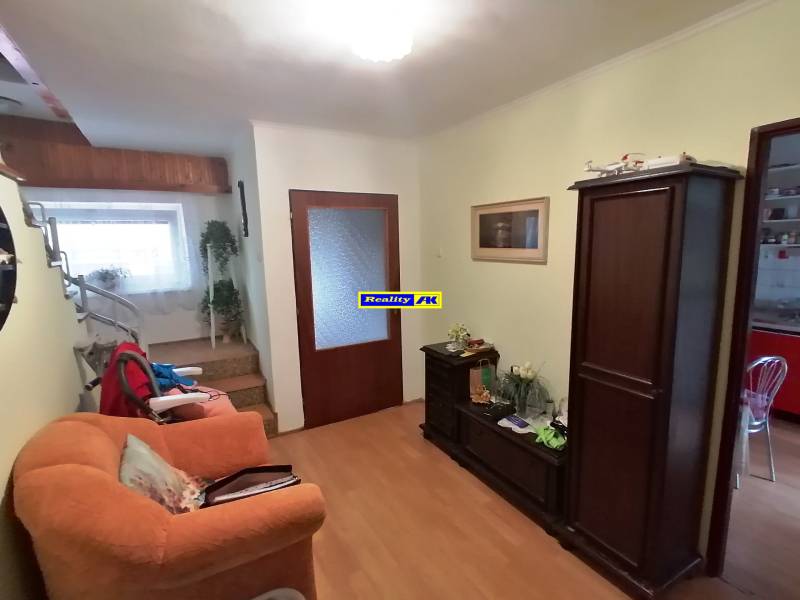 Living room in a family house with wooden furniture and a staircase.