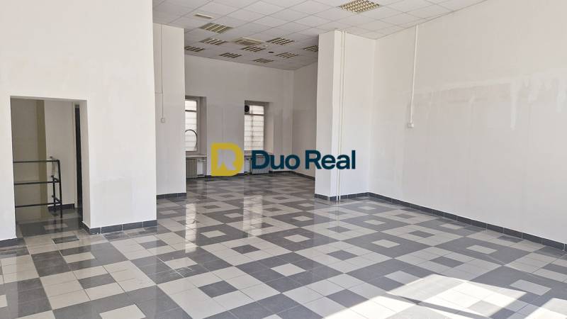 Spacious commercial spaces with tiled floors and high ceilings.