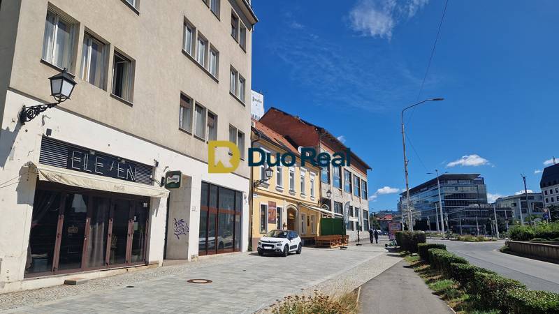 Commercial premises on Konventná Street in Bratislava - Old Town with cars and pedestrians.