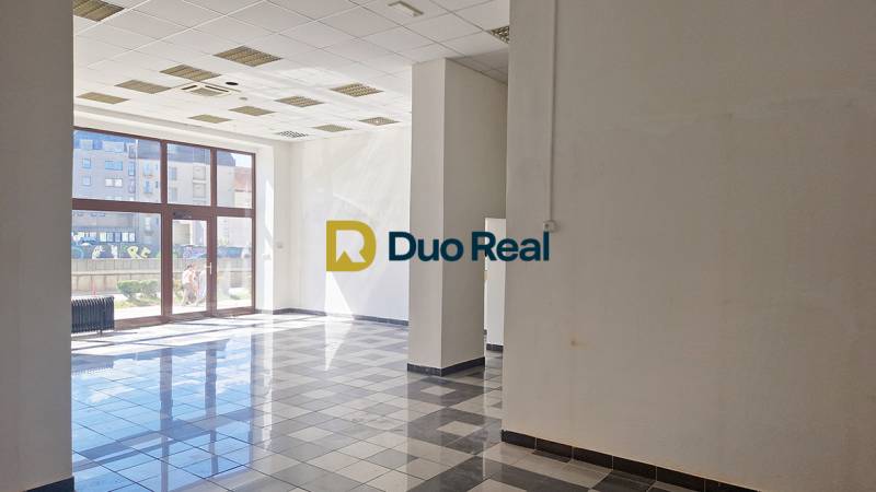 Spacious commercial spaces with large windows and tiled floors.