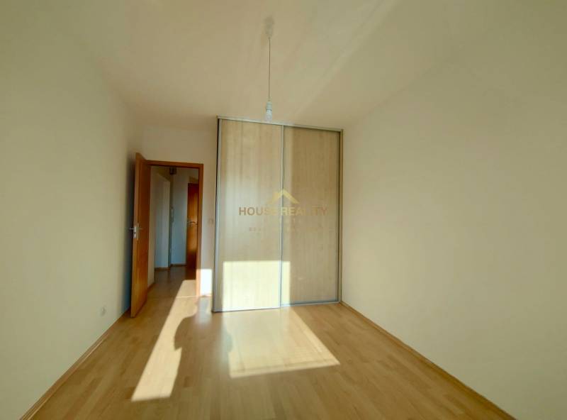 A room in a 3-room apartment with a wooden decor floor and a built-in wardrobe.