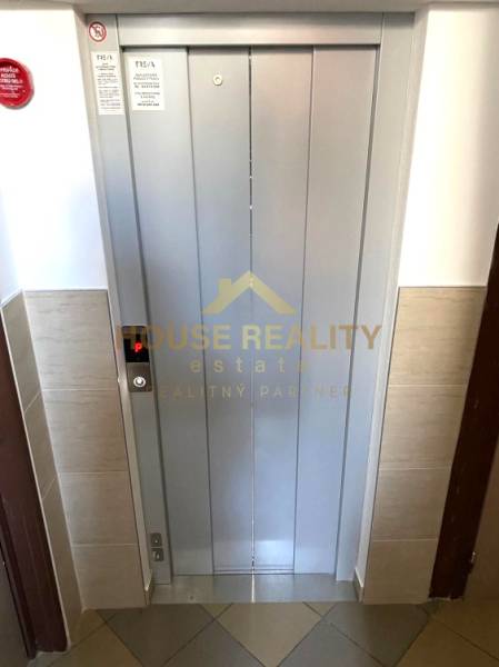 Elevator in a 3-room apartment with the real estate agency's logo on the door.