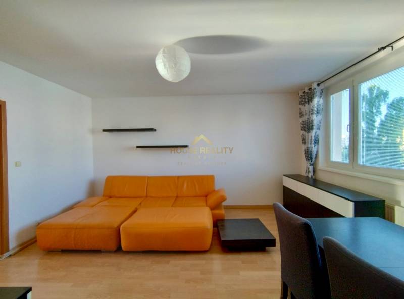 Living room with a sofa and a wooden decor floor in a 3-room apartment.