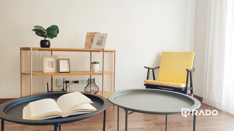 Interior of a 2-room apartment with decorative elements, a chair, and a table with a book.