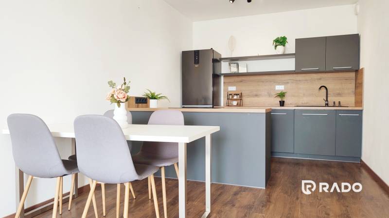 Kitchen with dining table and chairs, 2-room apartment with wooden flooring and decoration.