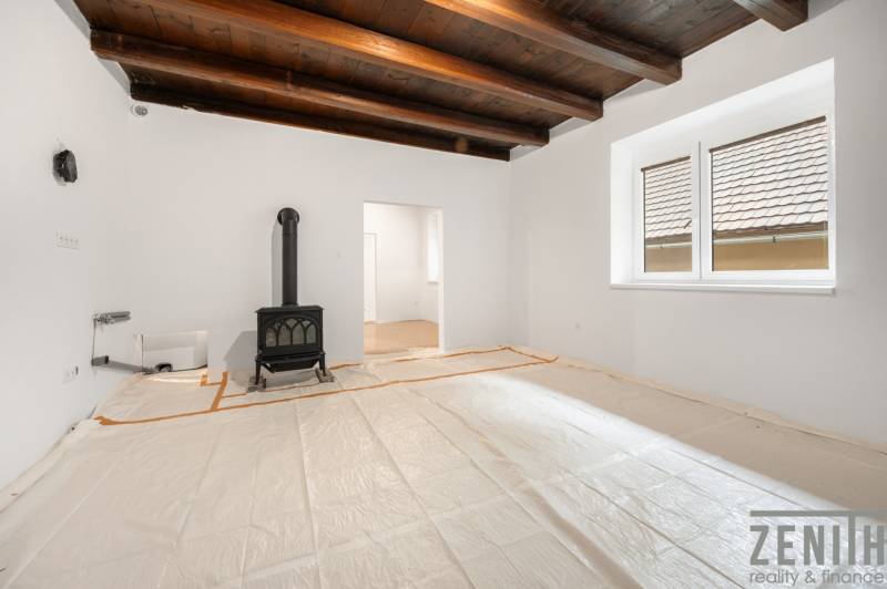 Living room with a wood-burning stove in a family house with a wooden ceiling.