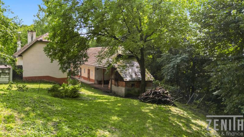 A family house on Dzurákovec in Brezová pod Bradlom surrounded by greenery and trees.