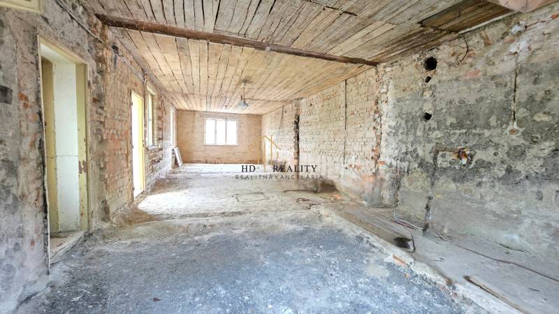 The interior of a family house with brick walls and an unfinished ceiling, ready for renovation.