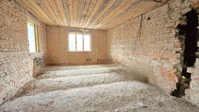 Unplastered brick walls in a family house, ongoing renovation, natural light from windows.