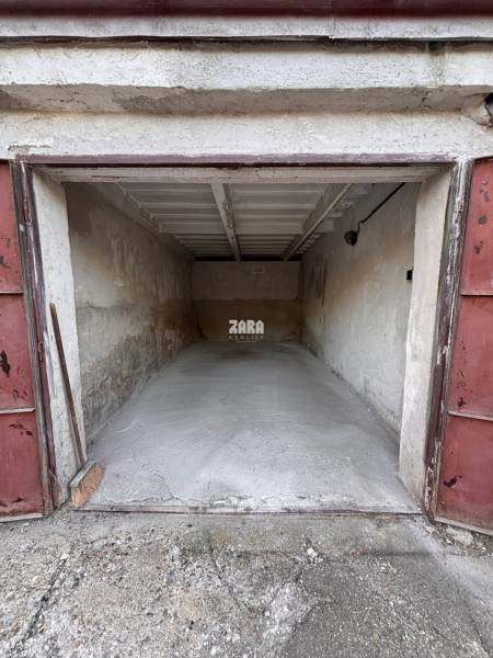 An open garage on Považská Street in Košice, in the Západ district, with a concrete floor.