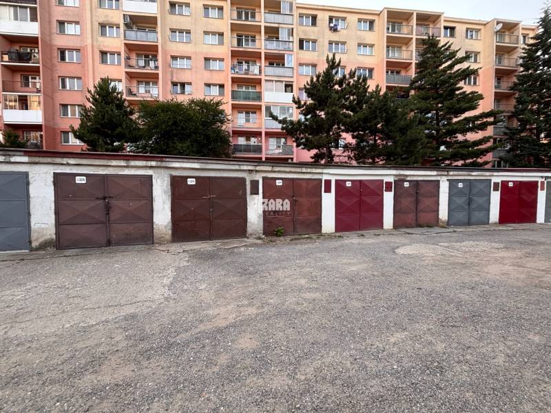 Garages on Považská Street in Košice - West district, with a panel building in the background.