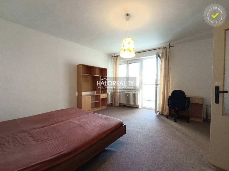 A room with a bed, a desk, and a shelf in a studio apartment, light curtain brake.