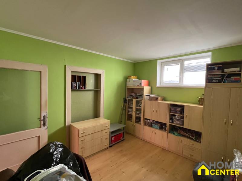 A room in a family house with wooden furniture and green walls.