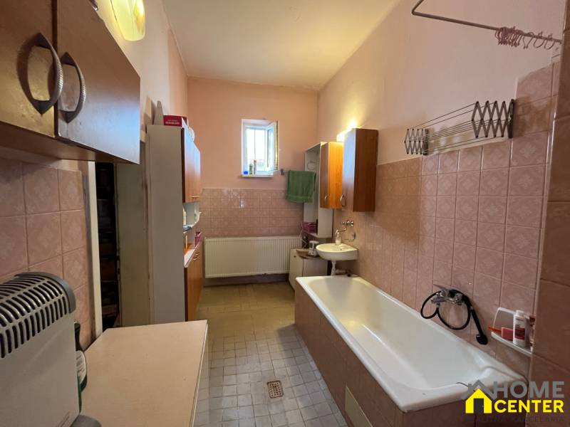 A bathroom in a family house with a bathtub, sink, and cabinets, cozy furnishings.