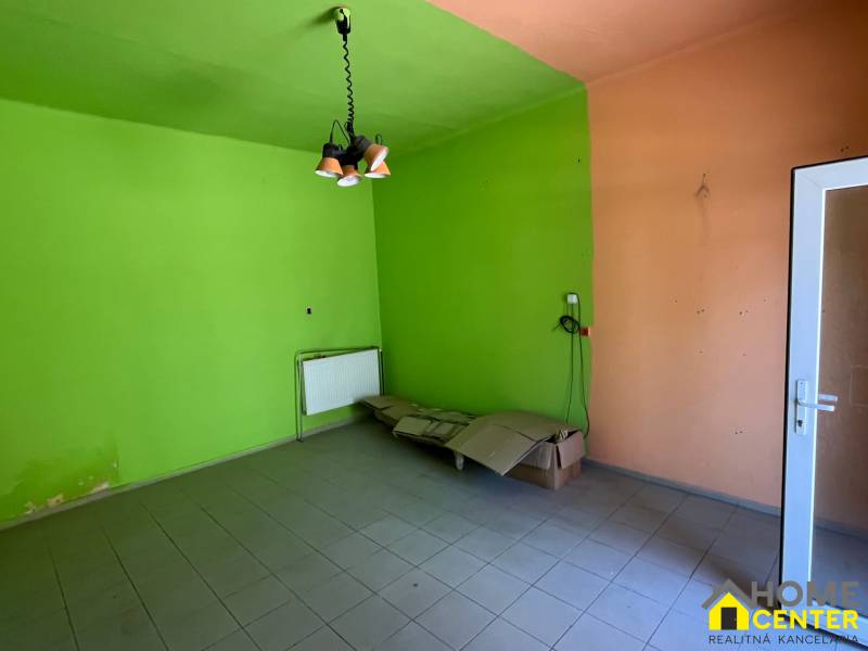 The interior of a family house with colorful walls, tiled floor, and a pendant light.