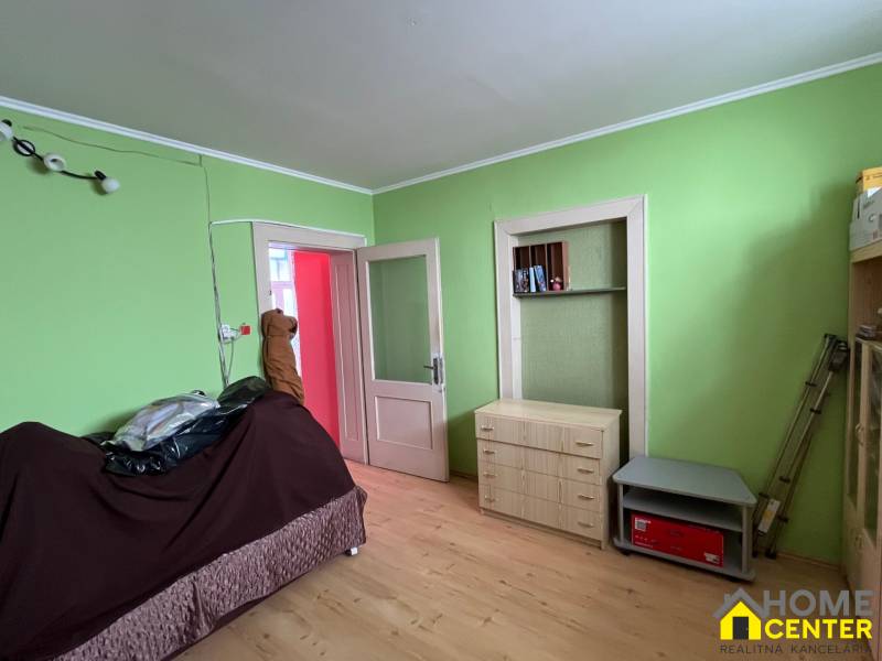 A room in a family house with wooden furniture and green walls.
