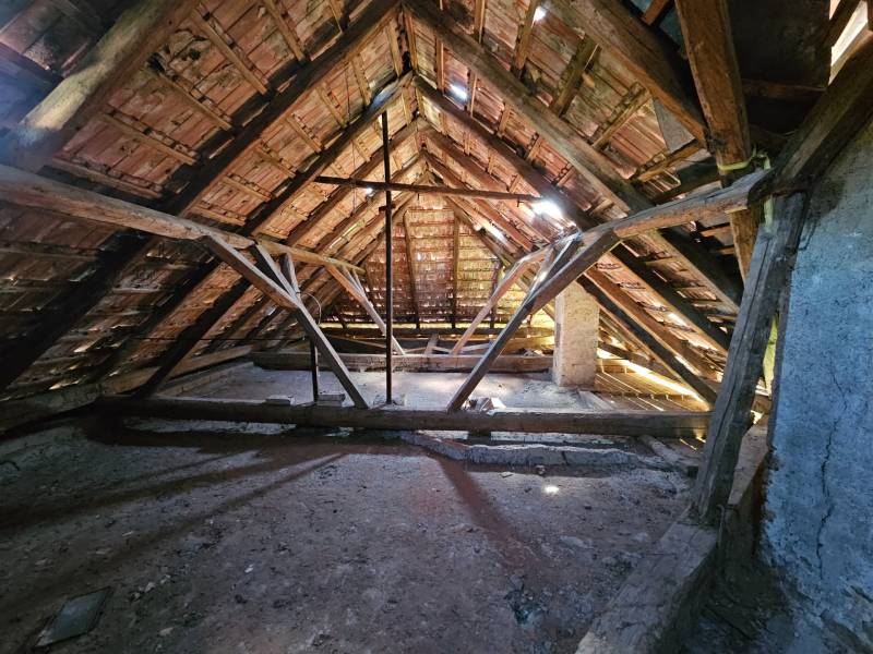 Attic with wooden structure and roof tiles in a family house.