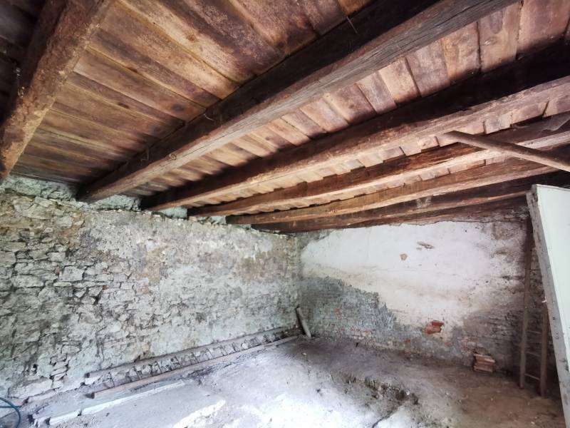 The interior of the family house has stone walls and a wooden ceiling.