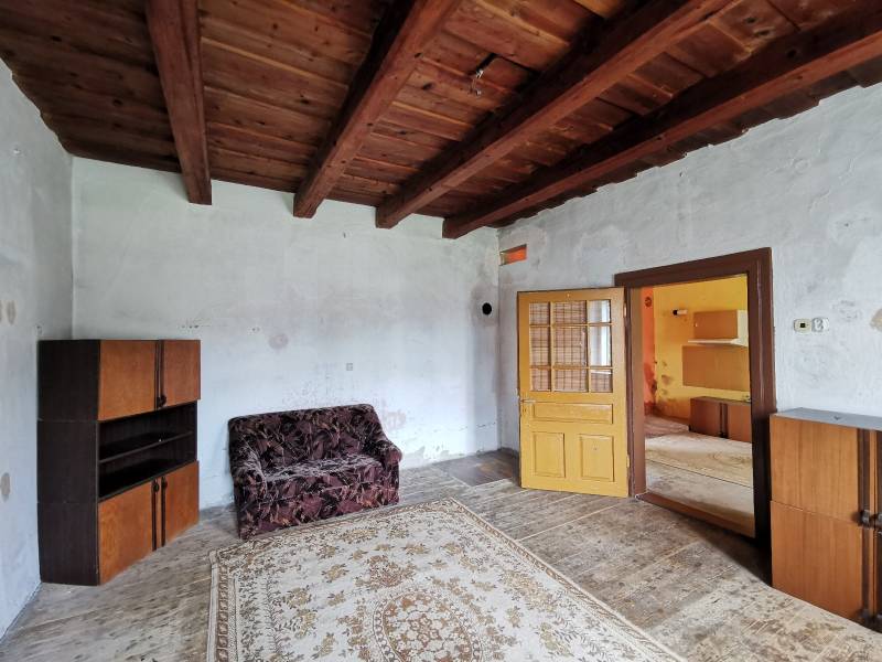A room with a wooden ceiling and retro furniture in a family house.