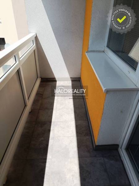A balcony with tiles and railing in a 1-room apartment, suitable for relaxation and leisure.