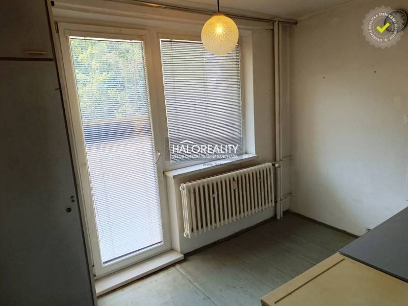 Interior of a 1-room apartment with blinds on the window and pendant lighting.
