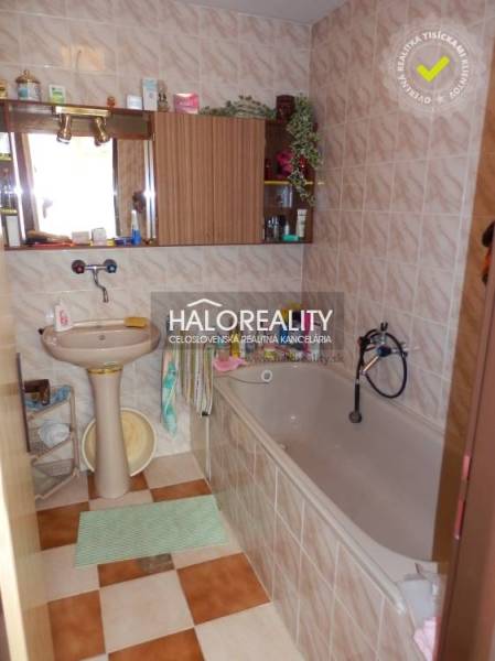 Bathroom in a family house with a bathtub, sink, and mirror.