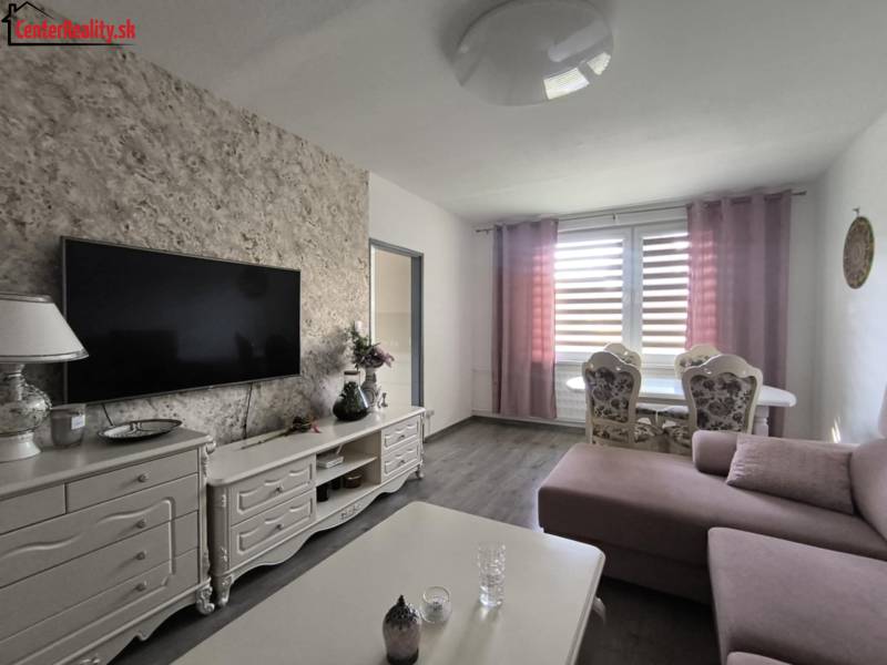 Living room in a 3-room apartment with a TV, sofa, and dining table.