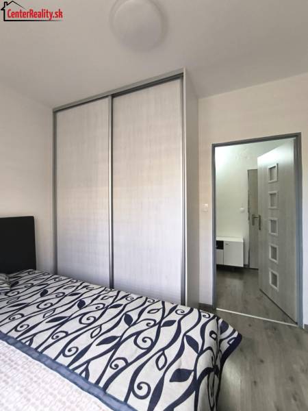 Bedroom with a sliding wardrobe and a bed in a 3-room apartment.