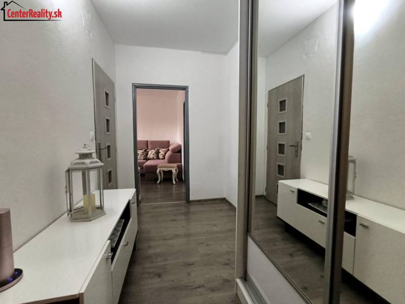 Interior of a 3-room apartment with storage space and a living room in the background.