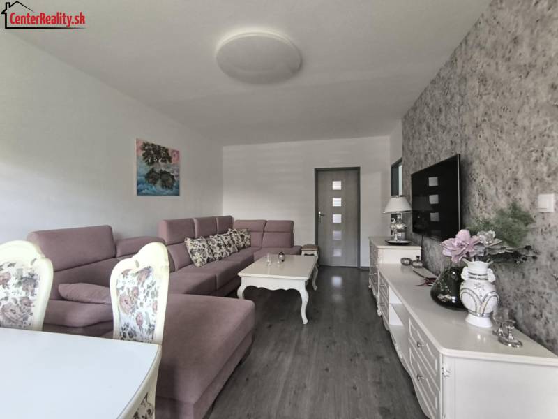 Living room in a 3-room apartment, with a sofa, decorative furniture, and a TV on the wall.