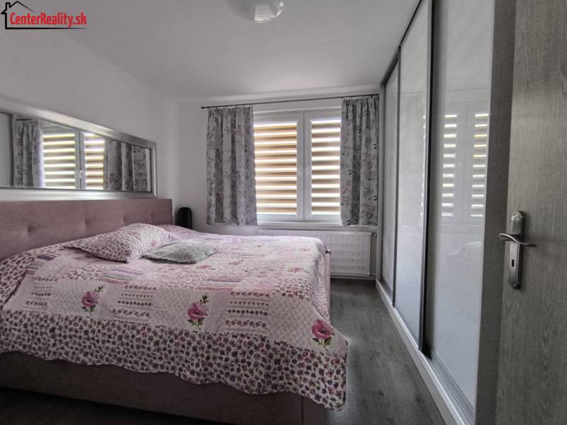 Bedroom in a 3-room apartment with a large bed, built-in wardrobe, and a window with curtains.