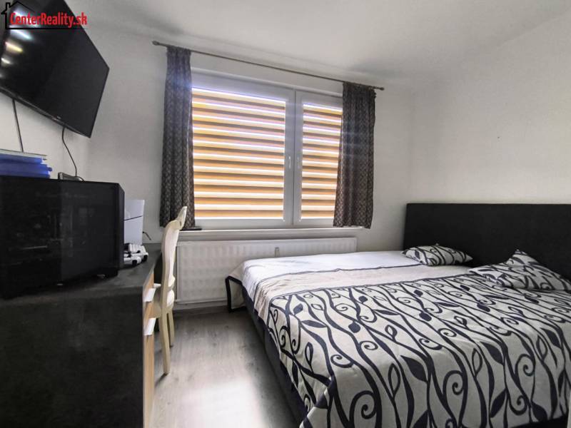 Bedroom with a bed, television, and a desk in a 3-room apartment.