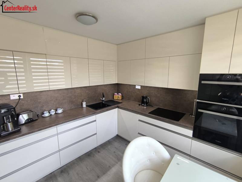 Kitchen in a 3-room apartment, modern cabinets and appliances, light shades.