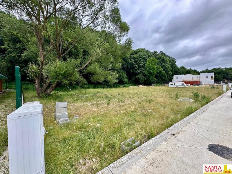 A plot in Borinka ideal for living, with a view of greenery and a nearby forest.