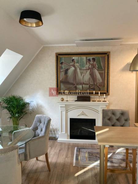Interior of a 2-room apartment with a fireplace, a painting of dancers, and comfortable armchairs.