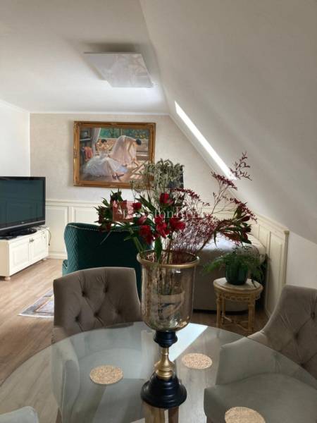 In the interior of a 2-room apartment, there is a dining table and a floral arrangement.