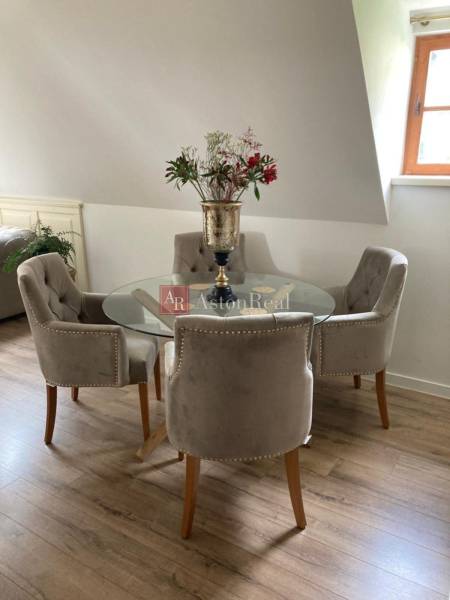 Dining area with a round table and stylish chairs in a 2-room apartment.