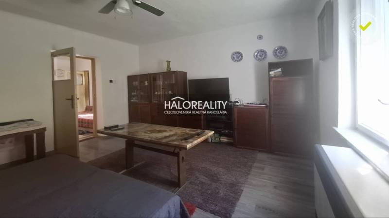 Living room in a family house with furniture and a television, light-colored walls.