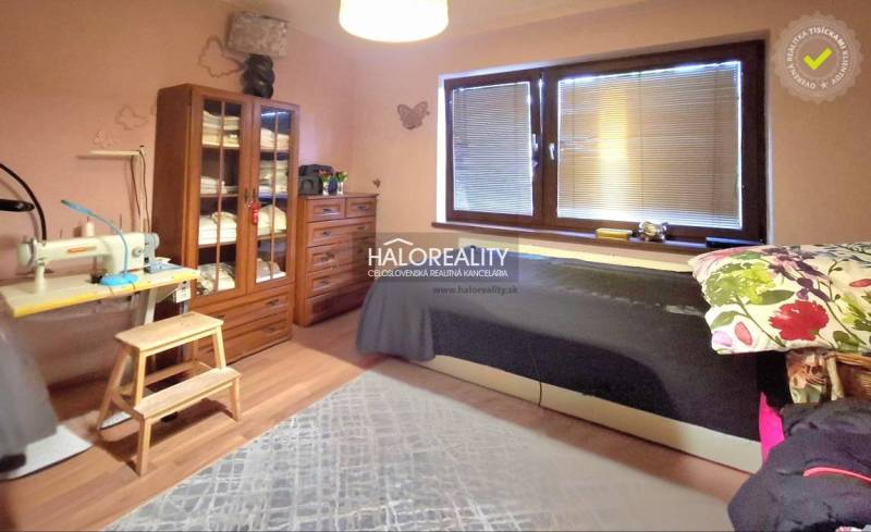 Bedroom in a family house, wardrobe, sewing machine, bed, large window with blinds.