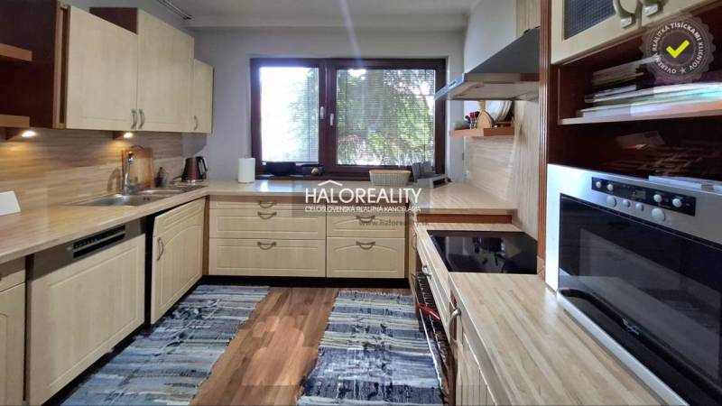 A kitchen in a family house with wooden cabinets and a kitchen counter.
