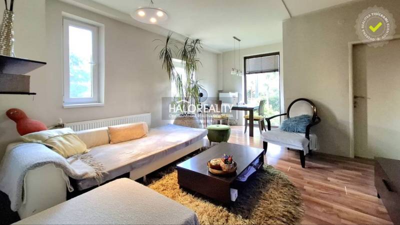 Living room with comfortable seating, dining table, and large windows in a family house.