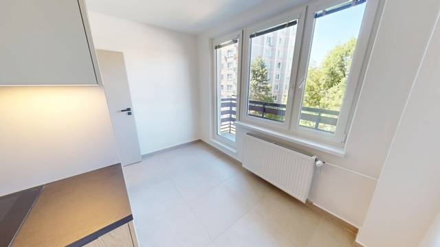 Kitchen in a 2-room apartment with large windows and a radiator.